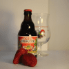 Botella de cerveza belga roja Cherry Chouffe y una copa de tulipa de la marca Brasserie D’Achouffe. Todo acompañado de unas fresas a modo de maridaje